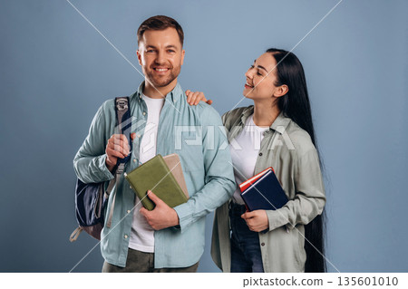Backpack and boxes, students. Man and woman are in the studio Backpack and boxes, students. Man and woman are in the studio 135601010