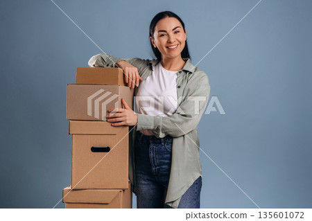 Bunch of boxes, moving concept. Beautiful woman is against background Bunch of boxes, moving concept. Beautiful woman is against background 135601072