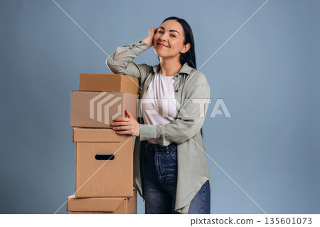 Bunch of boxes, moving concept. Beautiful woman is against background Bunch of boxes, moving concept. Beautiful woman is against background 135601073