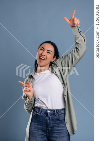 Pointing the fingers, fun. Beautiful woman is against background 135601083