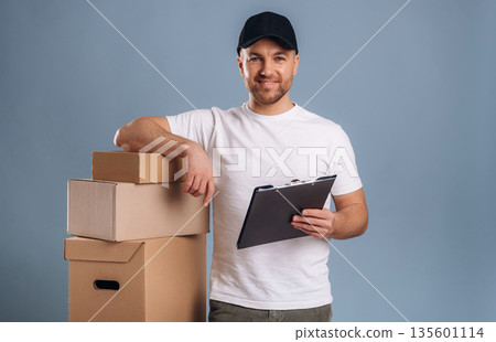 Worker of delivery service, with boxes. Handsome man is against background 135601114