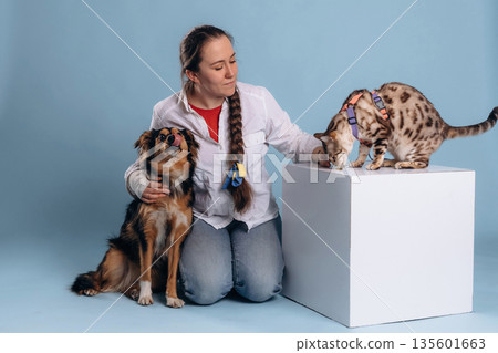 Woman doctor is sitting with mixed breed dog and Bengal cat Woman doctor is sitting with mixed breed dog and Bengal cat 135601663