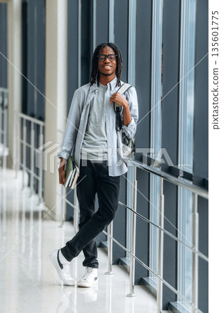 Books in hand. Student with backpack is in the corridor Books in hand. Student with backpack is in the corridor 135601775