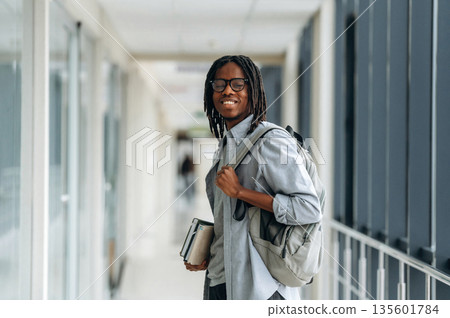 Student with backpack is in the corridor Student with backpack is in the corridor 135601784