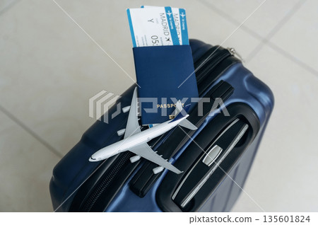 Top view of suitcase, plane toy, passport and tickets, tourism conception Top view of suitcase, plane toy, passport and tickets, tourism conception 135601824