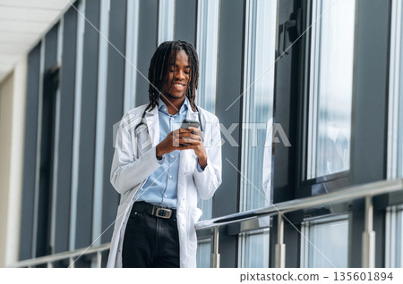 Joyful, positive facial expression. Young male black doctor is in the corridor 135601894