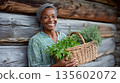 African female adult smiling with herb basket in rustic garden setting 135602072