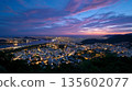 Stunning twilight cityscape overlooking urban lights and vibrant sunset 135602077