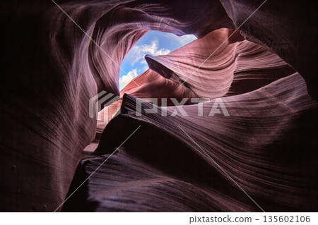 Curved sandstone ceiling with sky view in Antelope Canyon 135602106