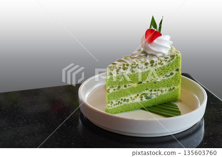 beautiful green and white Singapore Lod Chong Cake. Decorate with whipped cream. and rose petals placed on banana leaves, on a white ceramic plate on black marble floor, white and grey background, beautiful green and white Singapore Lod Chong Cake. Decorate with whipped cream. and rose petals placed on banana leaves, on a white ceramic plate on black marble floor, white and grey background, 135603760