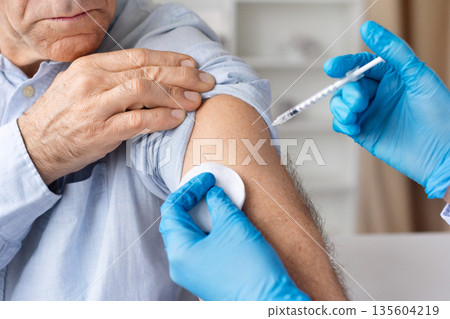 Senior male patient receiving vaccine injection from healthcare professional Senior male patient receiving vaccine injection from healthcare professional 135604219