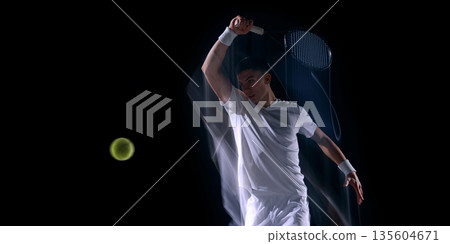 Tennis player overhead swing with motion effect on dark background. 135604671