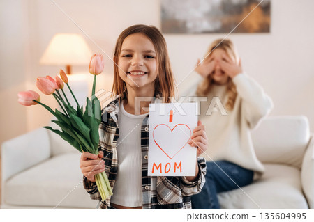I love mom text on gift card, with flowers. Mother and daughter are together in domestic room I love mom text on gift card, with flowers. Mother and daughter are together in domestic room 135604995