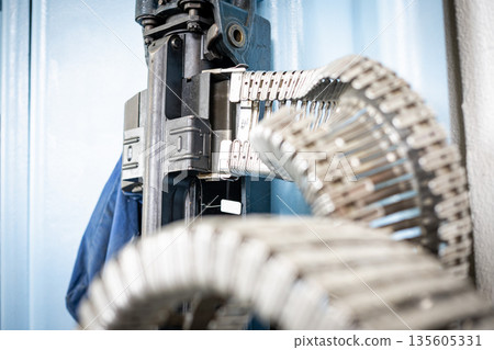 Industrial machine processing metal components on production line Industrial machine processing metal components on production line 135605331