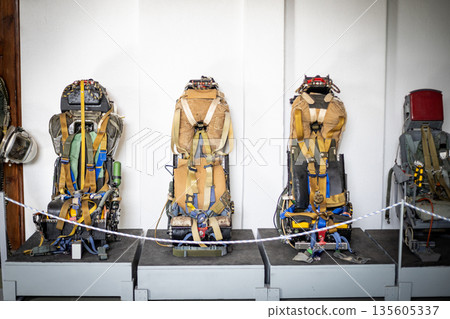 Military aircraft ejection seats displaying complex safety systems 135605337