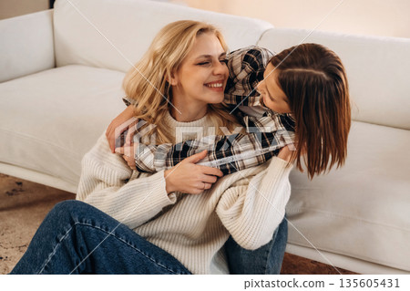Smiling, having fun. Mother and daughter are together in domestic room 135605431