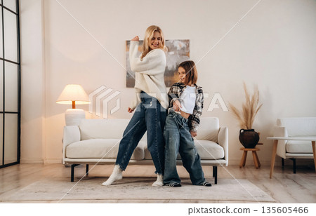 Party, dancing and having fun. Mother and daughter are together in domestic room Party, dancing and having fun. Mother and daughter are together in domestic room 135605466