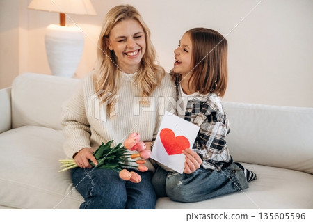 Expression of love at mother's day. Woman and her daughter are together in domestic room Expression of love at mother's day. Woman and her daughter are together in domestic room 135605596