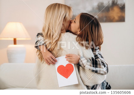 Sweet little hand drawn heart, mother's day. Woman and her daughter are together in domestic room Sweet little hand drawn heart, mother's day. Woman and her daughter are together in domestic room 135605606