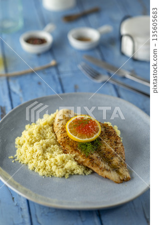 Grilled fish fillet with couscous, lemon, and red caviar Grilled fish fillet with couscous, lemon, and red caviar 135605683