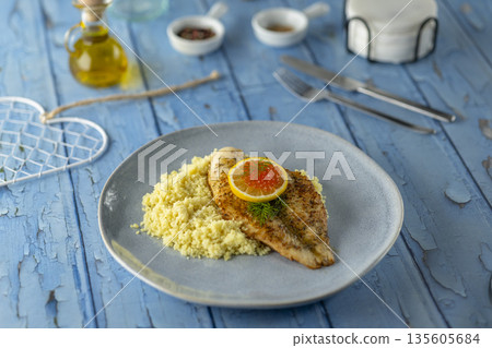 Pan fried fish filet with couscous, lemon, and caviar Pan fried fish filet with couscous, lemon, and caviar 135605684