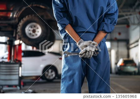 Tools in hands. Male mechanic is with car in garage 135605968