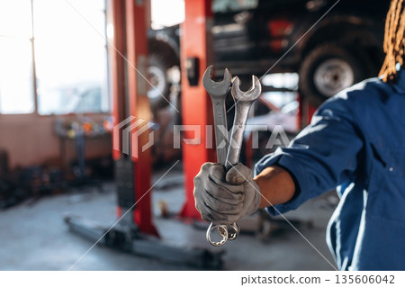 Male mechanic is with car in garage 135606042
