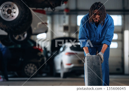 Male mechanic is with car in garage 135606045