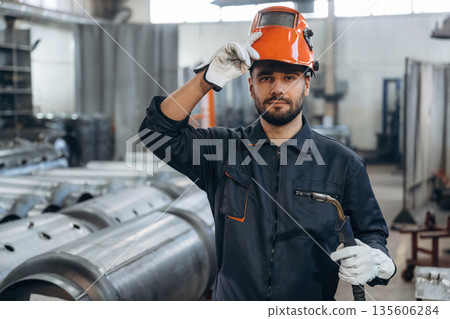 Welder is standing. Man is working in the factory 135606284