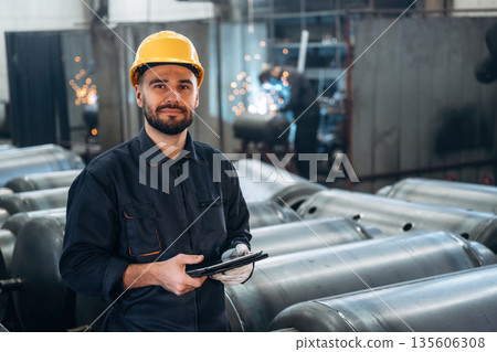 Digital tablet is in hands. Man is working in the factory 135606308