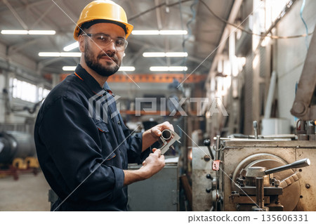 Measures the diameter of a metal object. Man is working in the factory 135606331