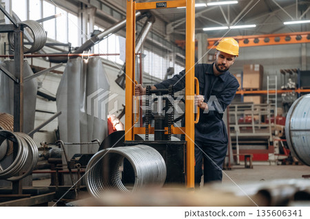 Using mover to transport circle shaped finished metal product. Man is working in the factory Using mover to transport circle shaped finished metal product. Man is working in the factory 135606341