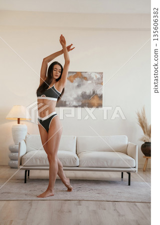Raising hands up. Young woman with slim body type is indoors 135606382