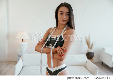 Weight loss conception. Young woman with slim body type is indoors Weight loss conception. Young woman with slim body type is indoors 135606414