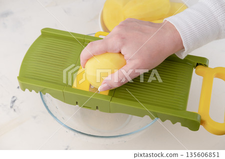 A woman rubs a potato on a grater close-up. Vitamins. Old people 135606851