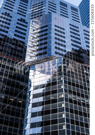 Architectural detail. Background of architecture. Modern glass background. Reflective glass background. Architecture geometry. Building architecture. Building background. Glass building window Architectural detail. Background of architecture. Modern glass background. Reflective glass background. Architecture geometry. Building architecture. Building background. Glass building window 135606930