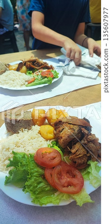 Close-up of fried potatoes and baked meat with rice and salad. Concept of Portuguese traditional food, gastrotourism 135607977