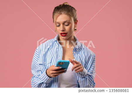 Pretty Blonde Woman Surfing Internet On Smartphone. Girl With Smile On Pink 135608081