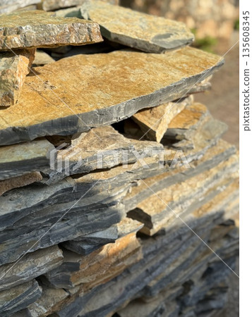 Stacked stone slabs outdoors creating rugged texture and background potential Stacked stone slabs outdoors creating rugged texture and background potential 135608345