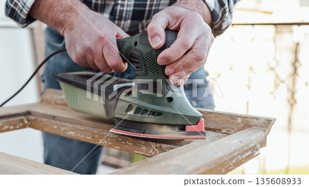 Carpenter at work, restoring an old wooden window. Carpentry. 135608933