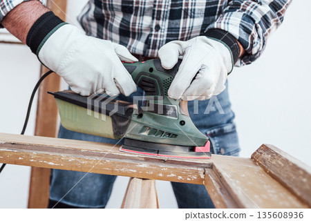 Carpenter at work, restoring an old wooden window. Carpentry. Carpenter at work, restoring an old wooden window. Carpentry. 135608936
