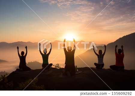Group of people doing yoga in nature during sunset or sunrise Group of people doing yoga in nature during sunset or sunrise 135609292