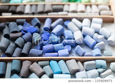 Soft pastels chalk collection in artist wooden case. Art supplies for pastel painting and drawing tools. Blue gray painter background. Soft pastels chalk collection in artist wooden case. Art supplies for pastel painting and drawing tools. Blue gray painter background. 135609973