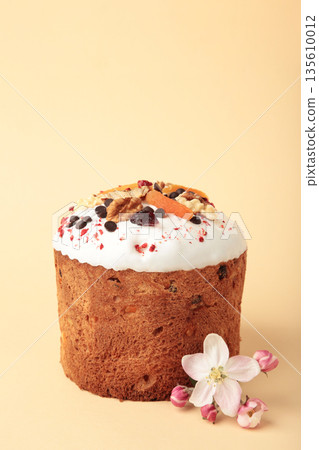 Traditional easter cakes with colorful sprinkles, with eggs on beige background. Vertical photo 135610012