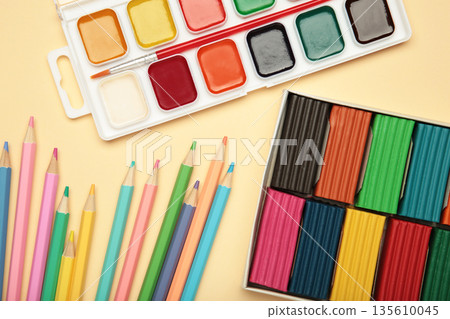 Colored pencils, plasticine and watercolor paints on beige background. 135610045
