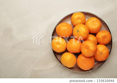 Fresh small tangerine mandarin orange in plate on light background. Space for text 135610048