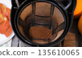 Ground coffee in a drip filter, process of brewing hot drink. Warm kitchen and morning routine concept  135610065