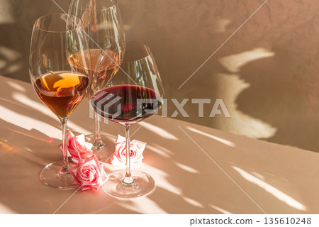 Three Wine Glasses with Rose, White and Red Wine. Romantic Still Life with Warm Light Three Wine Glasses with Rose, White and Red Wine. Romantic Still Life with Warm Light 135610248
