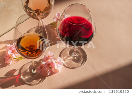 Three Wine Glasses with Rose, White and Red Wine. Romantic Still Life with Warm Light 135610250
