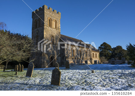 Church graveyard under light dusting of snow in winter sunshine Church graveyard under light dusting of snow in winter sunshine 135610284